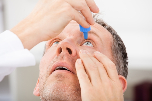 Man using eye drops for dry eyes