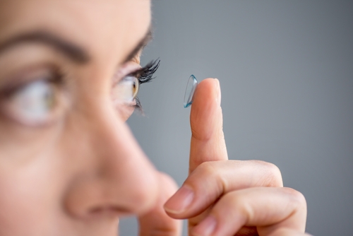 Woman inserting contact lens