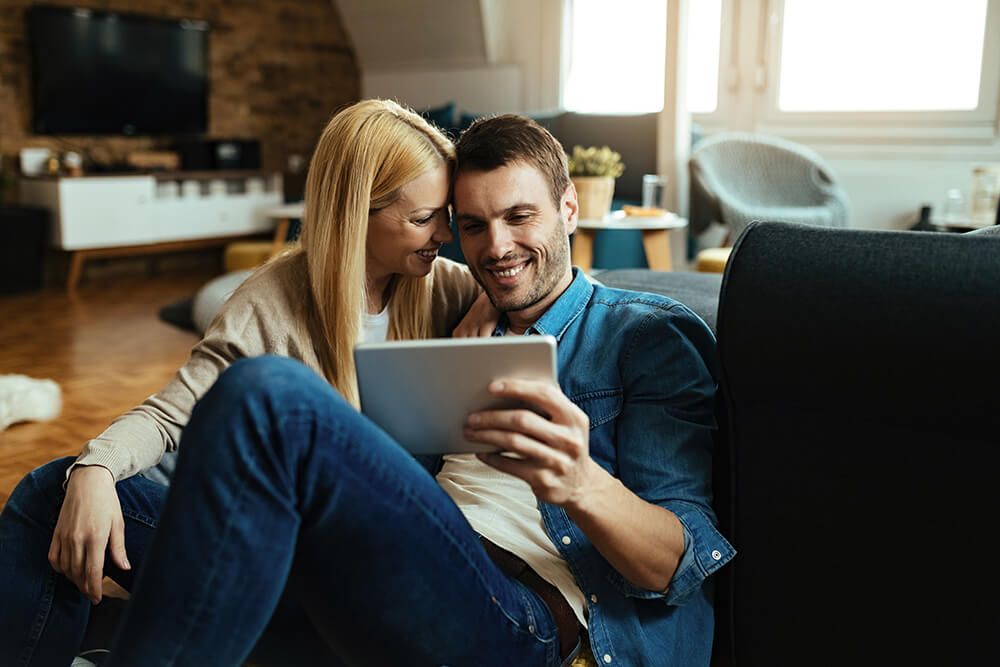 People Looking at a Tablet Computer and Smiling