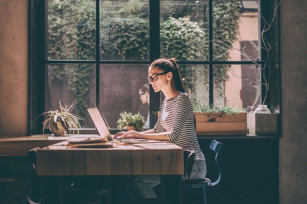 Woman wearing glasses working on laptop